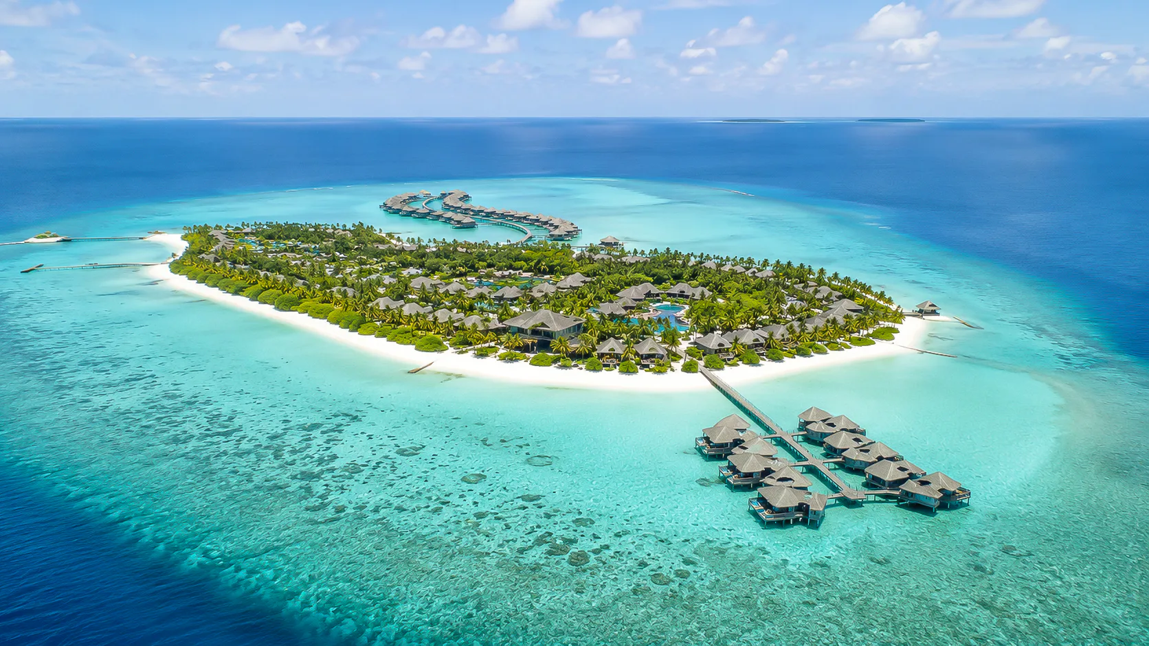 Aerial view of a Maldives island resort with turquoise lagoon