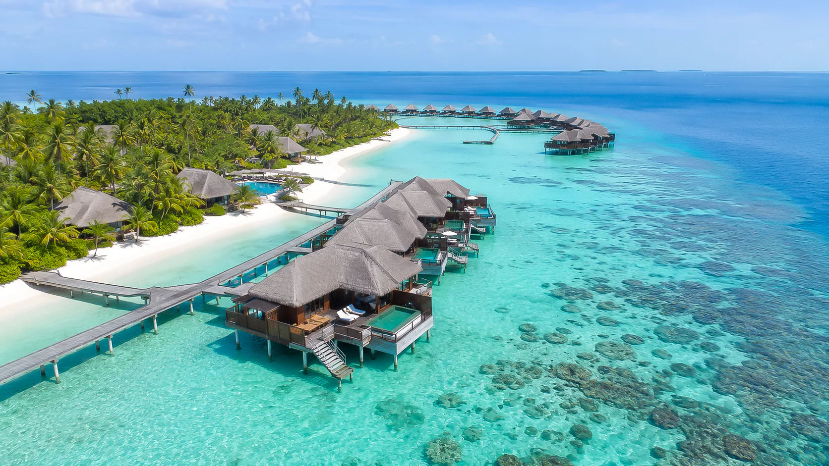 Overwater villas in luminous Maldives blue water